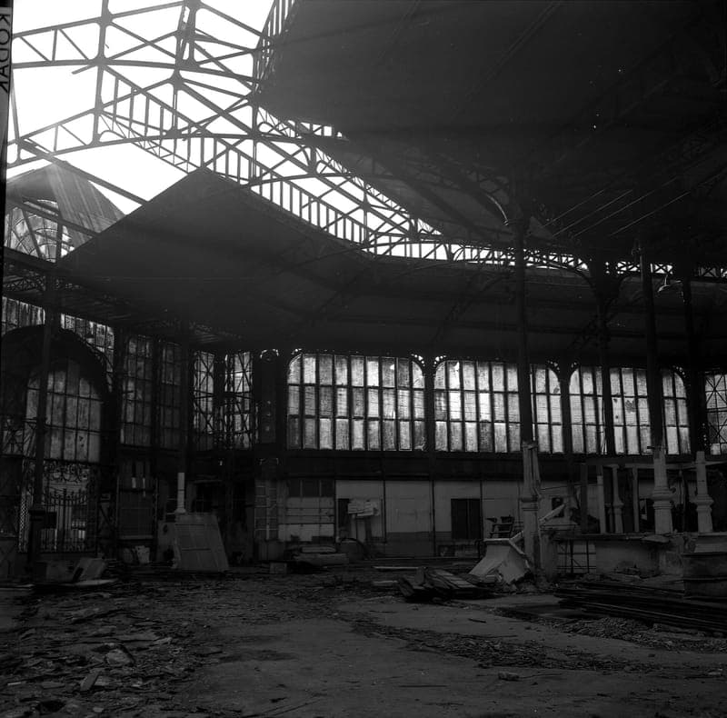 Intérieur vide de la halle métallique du marché des Carmes, charpente et vitres, gravats au sol