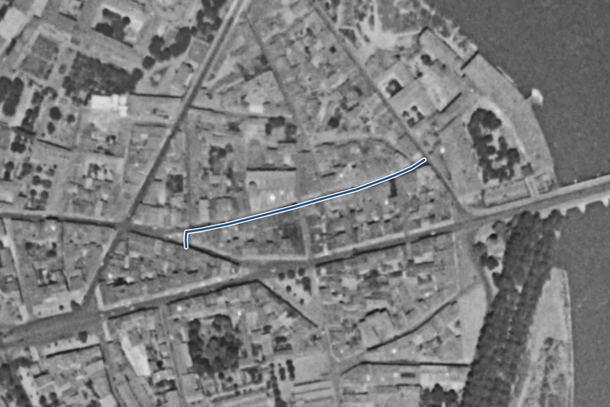 Vue aérienne de la grande-rue Saint-Nicolas en 1954, en noir et blanc, la voie tracée en bleu