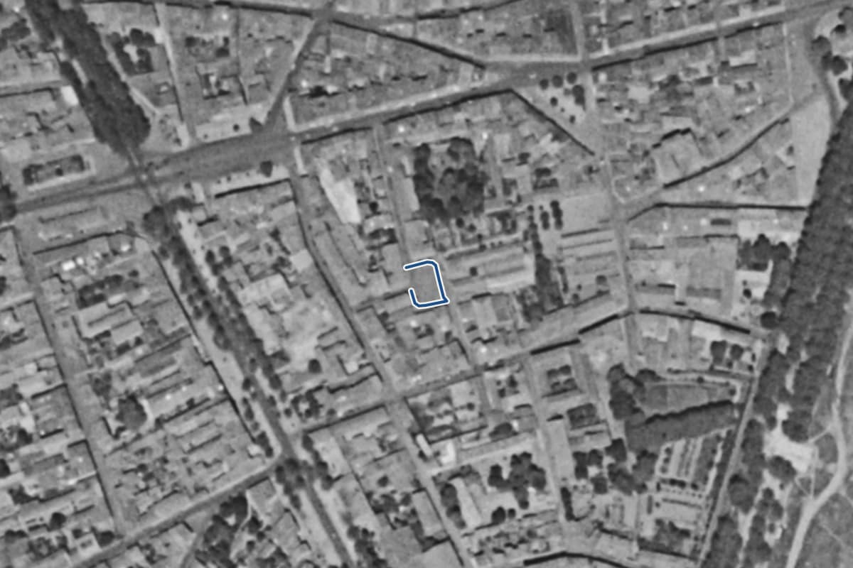 Vue aérienne de la place Benoît Arzac en 1954, en noir et blanc, la voie tracée en bleu