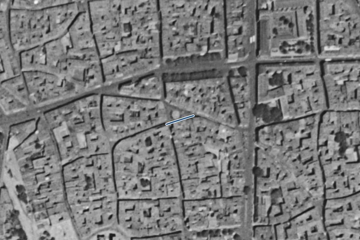 Vue aérienne de la place de la Trinité en 1954, en noir et blanc, la voie tracée en bleu