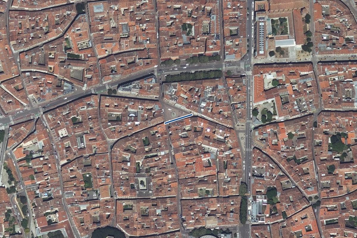 Vue aérienne de la place de la Trinité en 2025, au même cadrage, la voie tracée en bleu