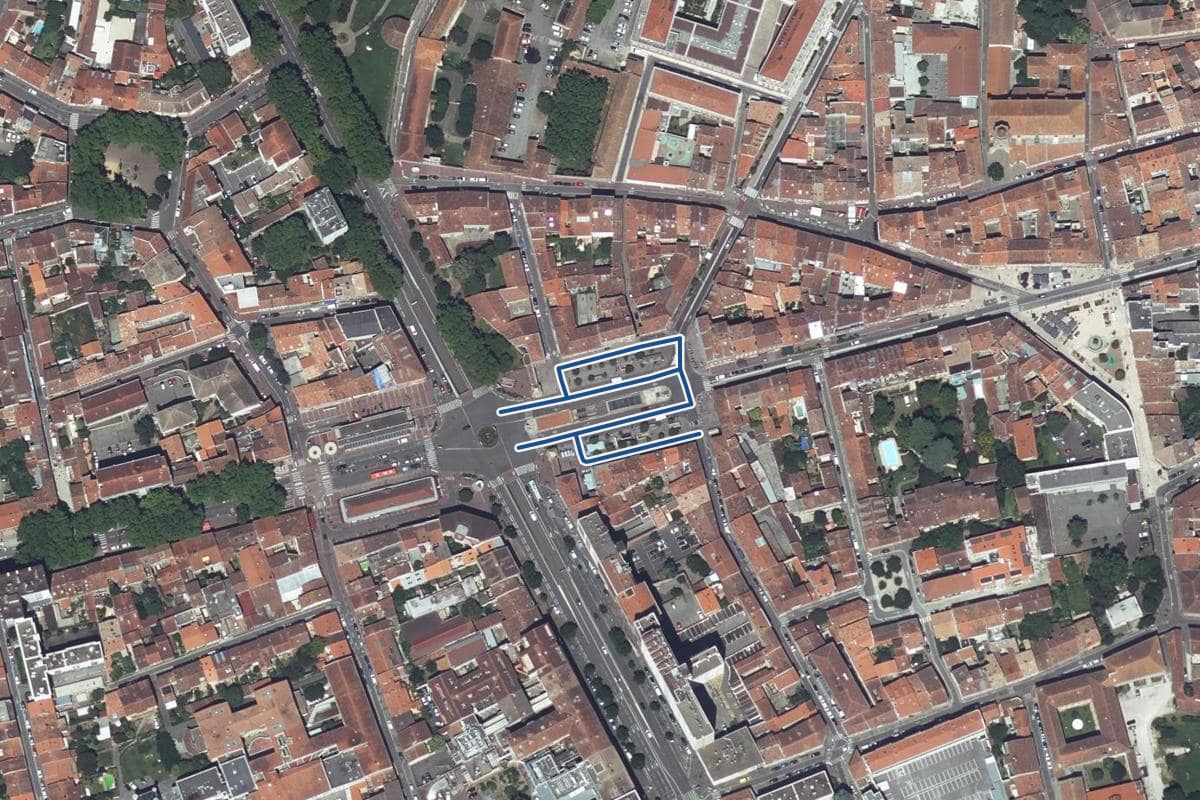 Vue aérienne de la place intérieure Saint-Cyprien en 2025, au même cadrage, la voie tracée en bleu