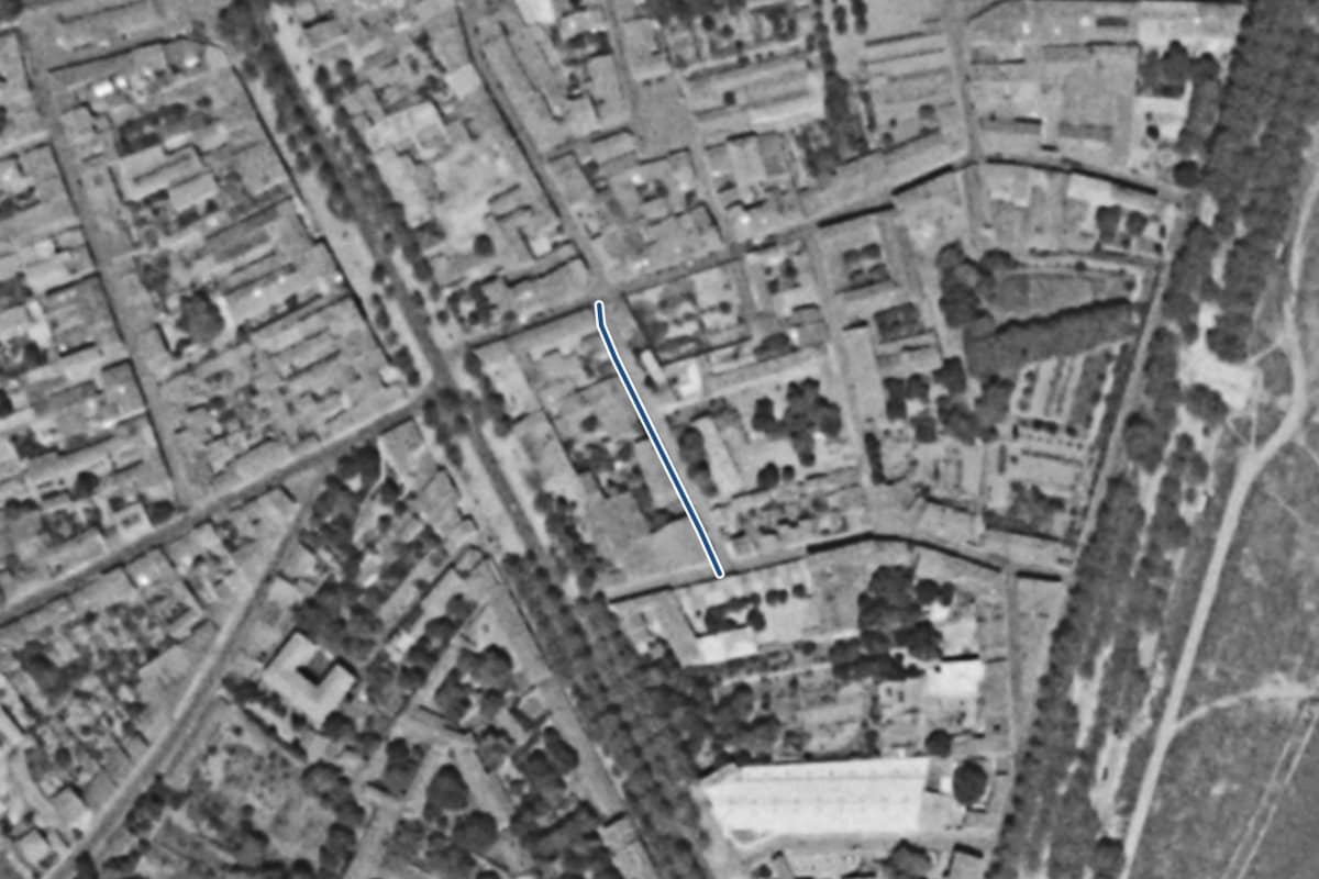 Vue aérienne de la rue Coupefer en 1954, en noir et blanc, la voie tracée en bleu