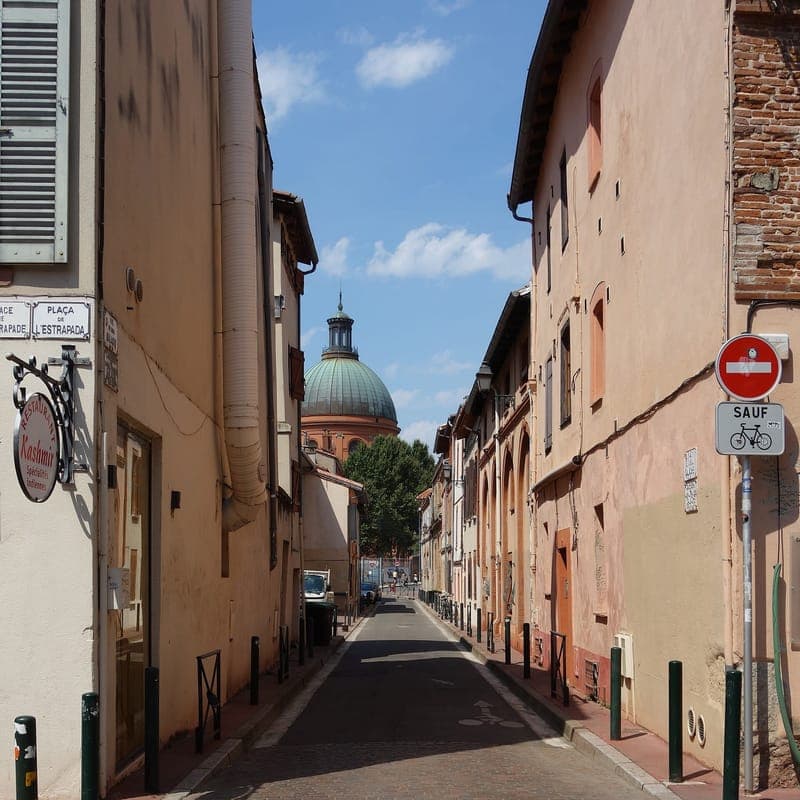 Rue de l'Amiral Galache : rue étroite aux façades ocres, dôme vert au fond, panneau de sens interdit, ciel bleu