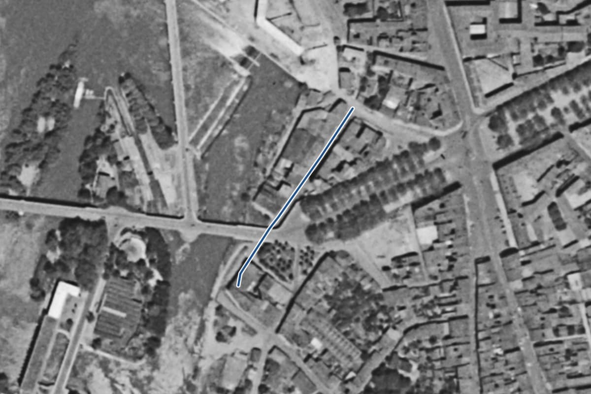 Vue aérienne de la rue de la Chaussée en 1954, en noir et blanc, la voie tracée en bleu