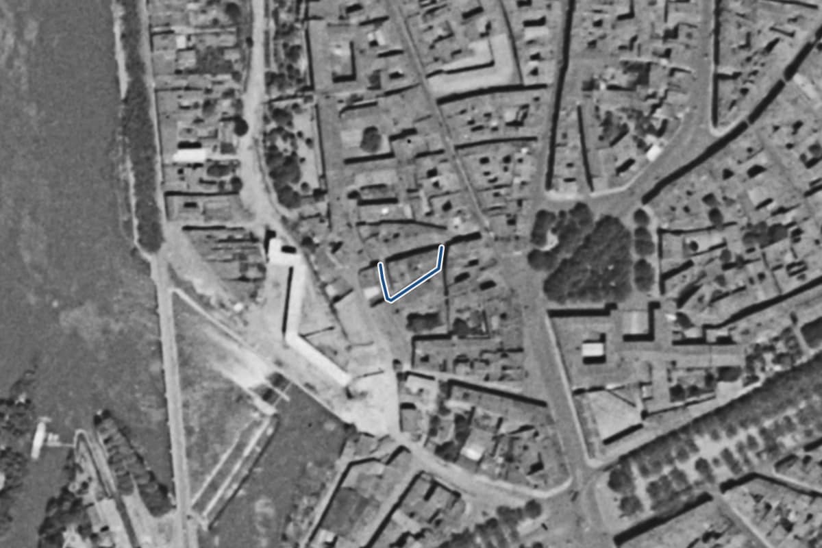 Vue aérienne de la rue de la Hache en 1954, en noir et blanc, la voie tracée en bleu