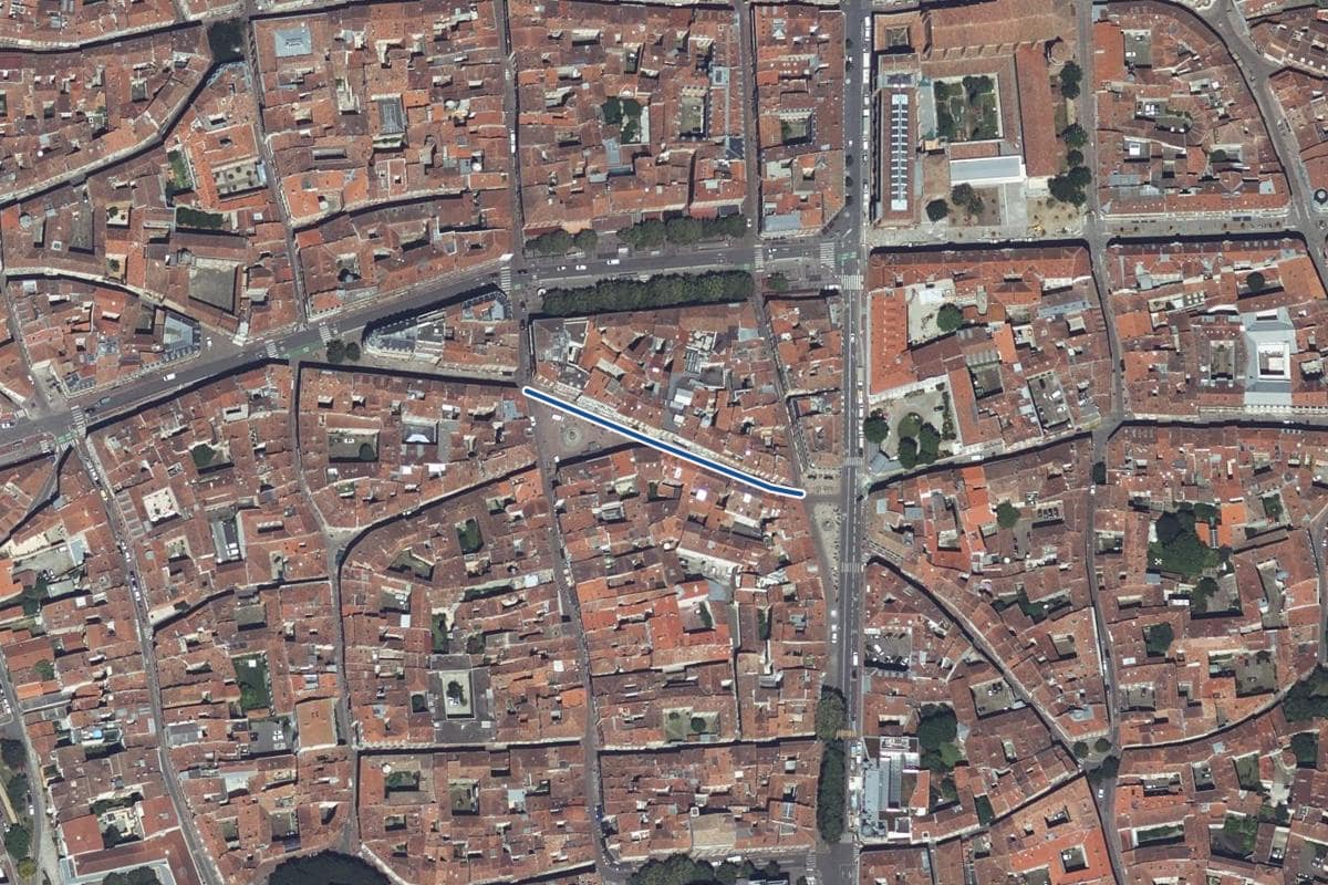 Vue aérienne de la rue de la Trinité en 2025, au même cadrage, la voie tracée en bleu