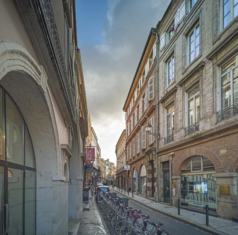 Rue des Couteliers : rue étroite bordée de façades de brique, vélos en stationnement au premier plan
