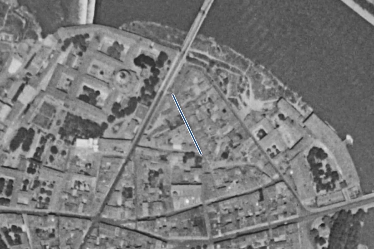 Vue aérienne de la rue des Novars en 1954, en noir et blanc, la voie tracée en bleu