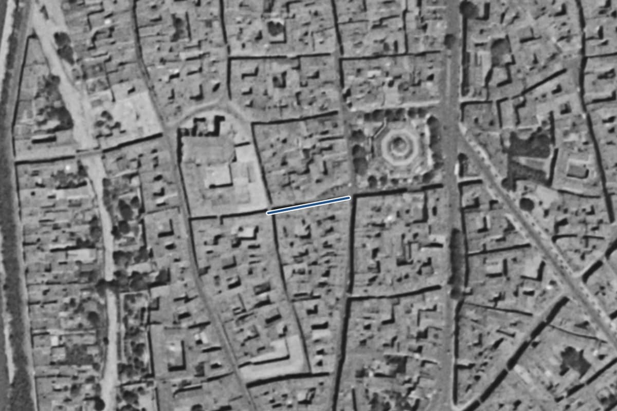 Vue aérienne de la rue des Prêtres en 1954, en noir et blanc, la voie tracée en bleu