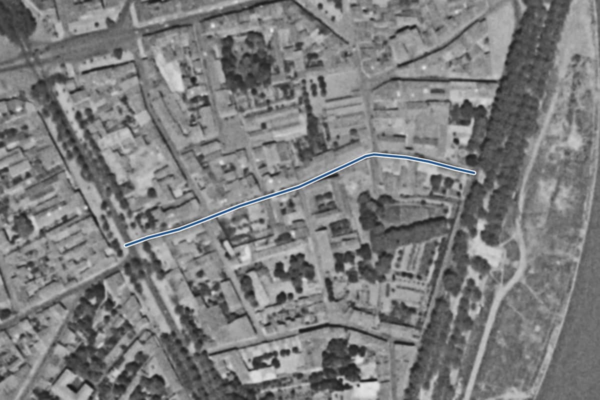 Vue aérienne de la rue des Teinturiers en 1954, en noir et blanc, la voie tracée en bleu