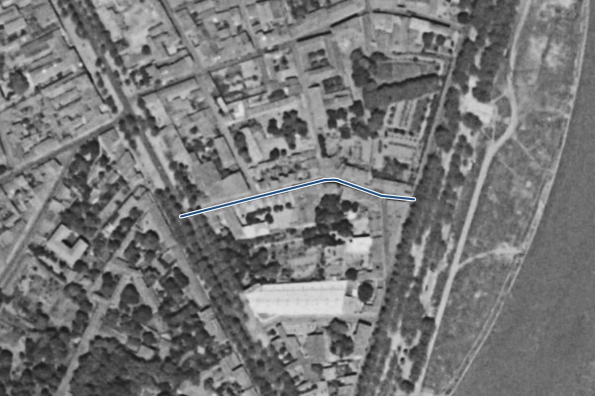 Vue aérienne de la rue Marie-Magné en 1954, en noir et blanc, la voie tracée en bleu